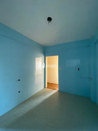 Interior de um cômodo com paredes azul claro e porta de acesso.