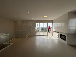 Sala ampla com piso de cerâmica e vista para o exterior.