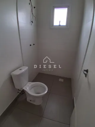 Foto de um corredor interno com um vaso sanitário branco e uma janela.
