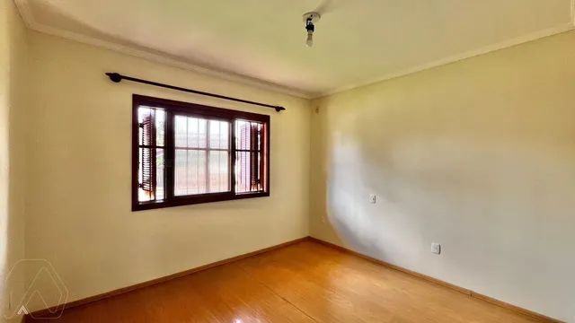 Uma sala de estar com piso de madeira e uma grande janela.