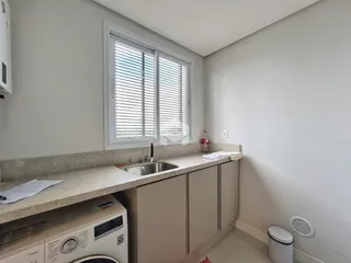 Bancada da cozinha com janela e armários.