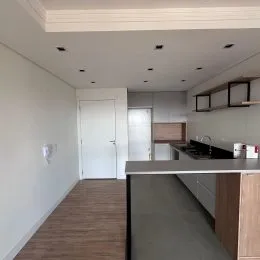 Corredor interno com paredes brancas e porta branca.