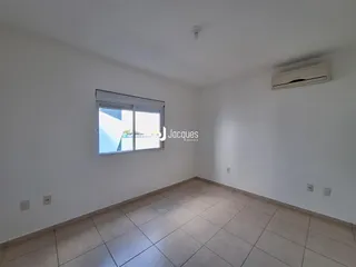 Ambiente interno de uma sala com piso de cerâmica e janela.