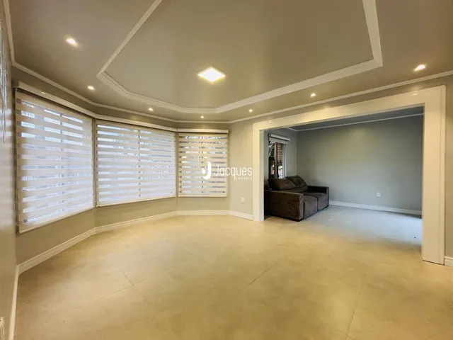 Sala de estar com paredes claras e molduras brancas em um imóvel no Brasil.