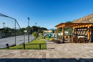 Área externa com gramado, quadra esportiva e estrutura de madeira.