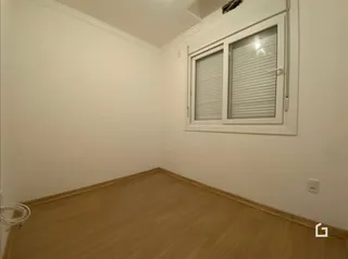 Foto de um cômodo interno com piso de madeira clara e paredes brancas.