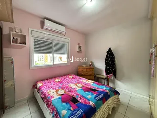 Quarto com parede rosa e cama decorada em Lajeado, Brasil.