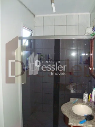 Foto de um interior com paredes de azulejo e divisória de vidro.