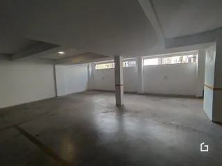 Imagem de um espaço interno com paredes brancas e teto plano.