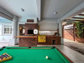 Sala de estar com lareira de tijolos e mesa de bilhar.