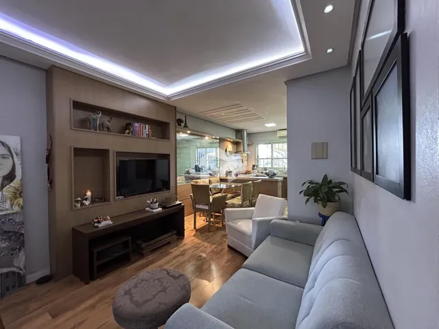 Sala de estar moderna com sofá e decoração em madeira.