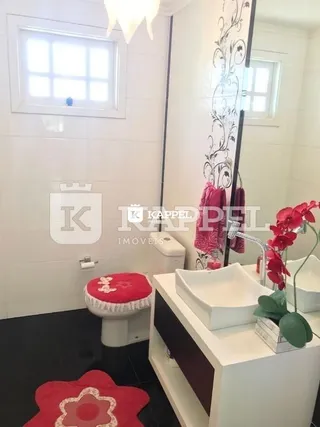 Foto de um banheiro interno com piso escuro e um vaso sanitário branco.