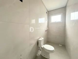 Foto de um banheiro interno com revestimento cerâmico e janela.