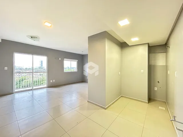 Ambiente interno de uma sala ampla com piso de cerâmica clara.