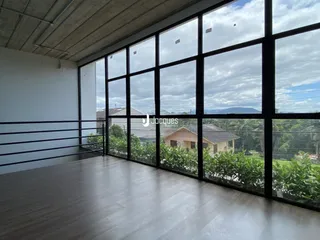 Sala de estar com grandes janelas que dão para o exterior.