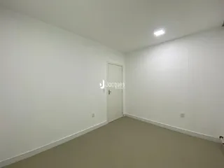 Foto de um cômodo vazio com paredes brancas e piso claro.