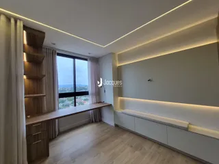 Sala de estar com piso de madeira clara e iluminação embutida.