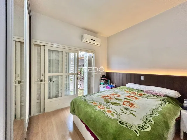 Quarto com cama e porta de vidro em um imóvel no Brasil.