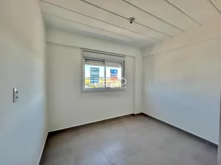 Ambiente interno de uma sala com paredes brancas e piso de cerâmica.