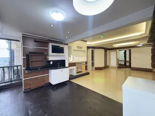 Sala de estar com piso de madeira e lareira moderna.