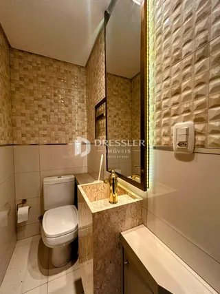 Banheiro com revestimento de cerâmica e louças sanitárias.