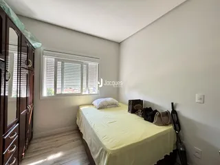 Quarto com cama e armário de madeira em um imóvel.