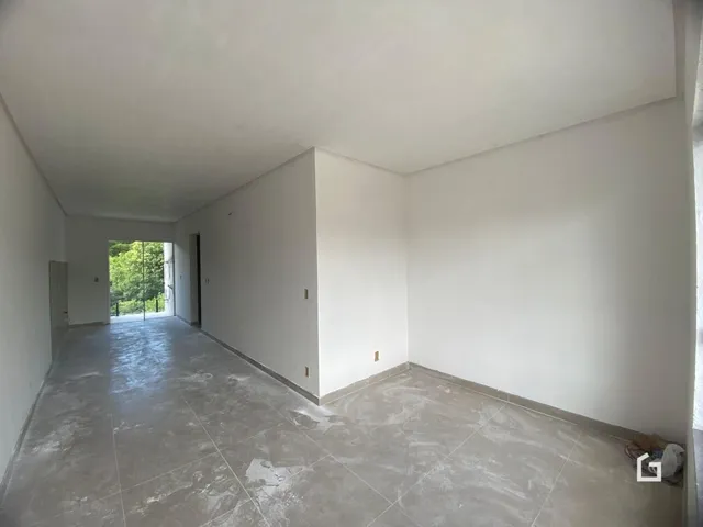 Hall de entrada com piso de concreto e paredes brancas.