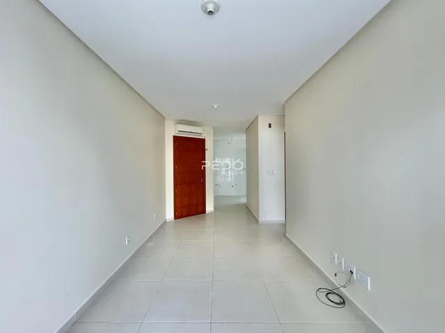 Corredor interno de uma residência com piso de cerâmica clara.