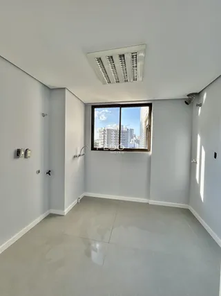 Vista interna de um corredor com janela de grande porte em um imóvel.