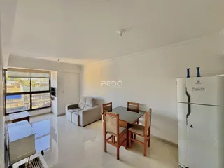 Sala de estar com sofá e mesa de jantar em um imóvel no Brasil.