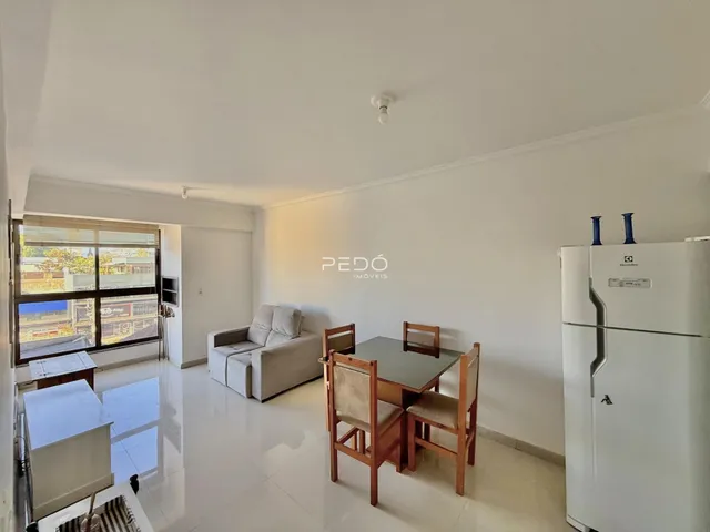 Sala de estar com sofá e mesa de jantar em um imóvel no Brasil.