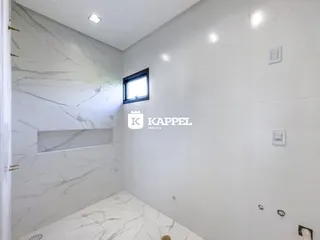 Ambiente interno com revestimento em mármore branco e piso claro.