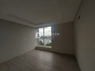 Ambiente interno de uma sala com piso de madeira e janela.