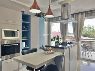 Cozinha moderna com ilha e vista para o exterior.