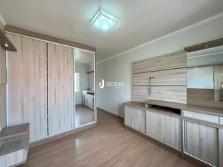 Quarto com armários em madeira e piso de madeira clara.