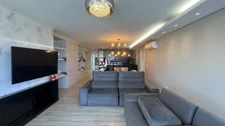 Sala de estar moderna com sofás cinzas e piso claro.