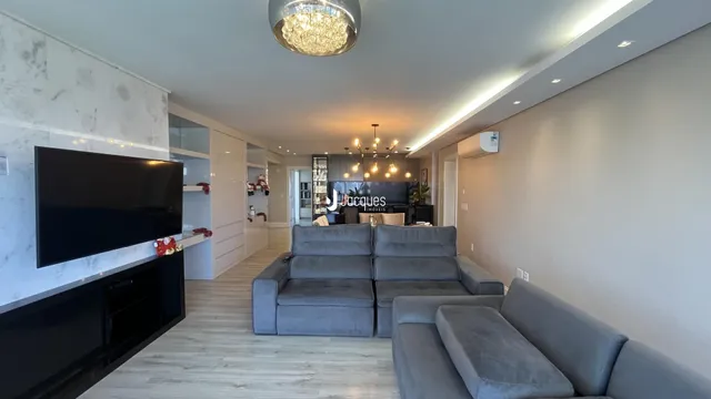 Sala de estar moderna com sofás cinzas e piso claro.