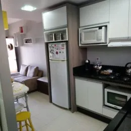 Cozinha com armários brancos e eletrodomésticos instalados.