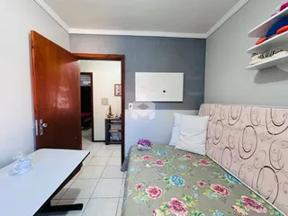 Quarto com cama e parede cinza.
