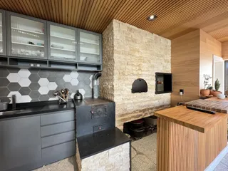Cozinha moderna com armários cinzas e parede de pedra na Lajeado.