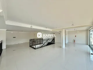 Vista ampla de um ambiente interno com piso de porcelanato claro e estrutura de guarda-corpo.