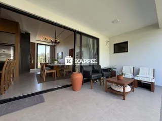 Sala de estar com área de jantar integrada e grande abertura para a área externa.