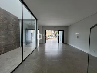 Ambiente interno de uma sala ampla com piso de concreto em uma residência.