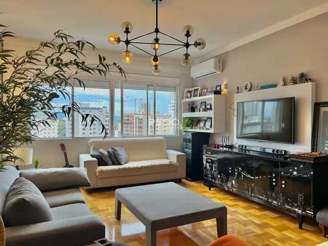 Sala de estar com piso de madeira e vista da cidade.