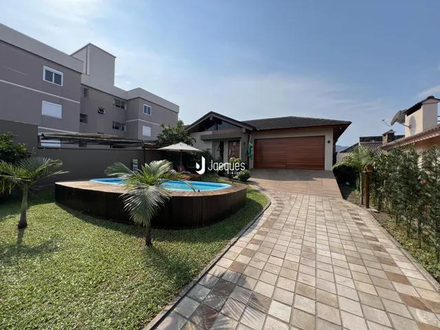 Vista externa da residência com piscina e jardim.