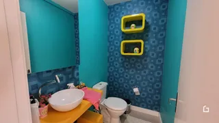 Foto de um banheiro com pia e vaso sanitário.