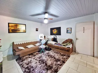 Sala de estar com sofá e tapete grande no ambiente.