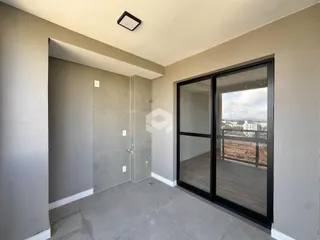Hall de entrada com piso de concreto e porta de vidro voltada para a vista.