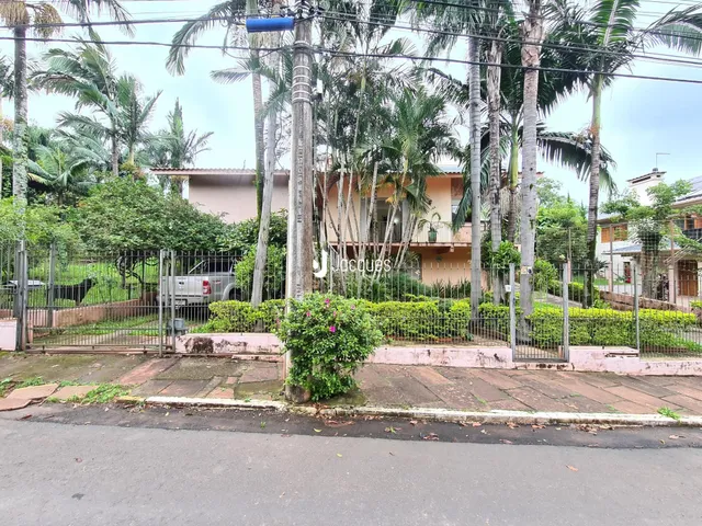 Fachada de uma residência em Lajeado, Brasil, com cerca e vegetação.