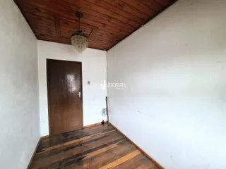 Uma vista interna de um ambiente com piso de madeira e parede branca.